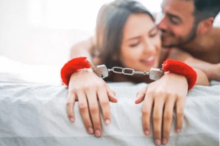 kinky  couple, kinky woman wearing red bdsm play handcuffs